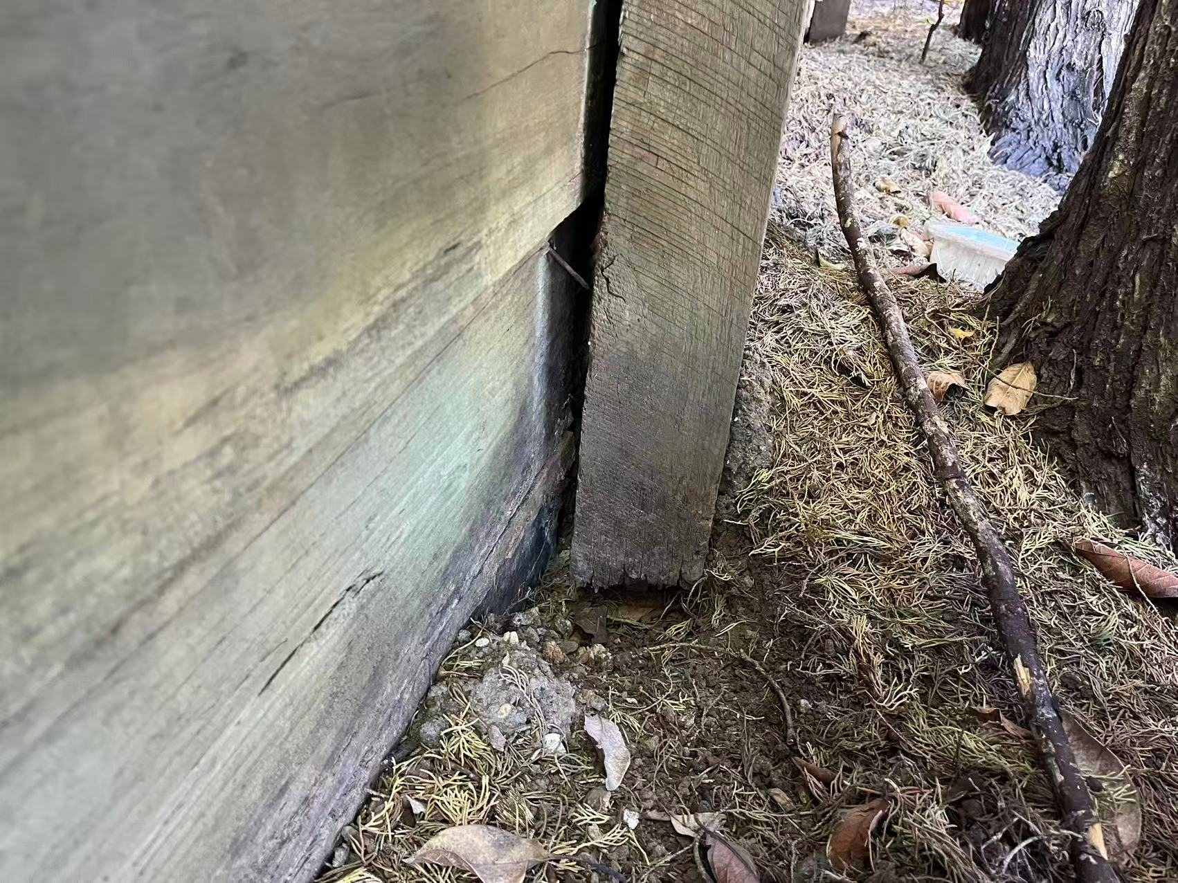 Close-up detail of a timber fence post at its base along the finished fence.