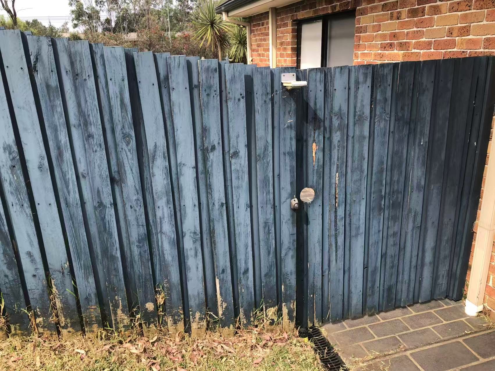 Finished timber gate in a consistent dark finish along the boundary.