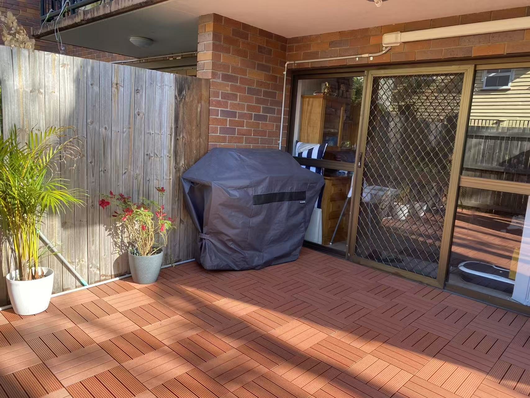 Overview of a compact outdoor patio area finished with modular deck tiles.